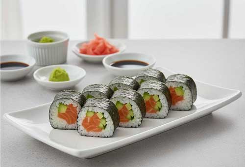 роллы с лососем авокадо и огурцом на тарелке
