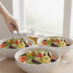 три тарелки с готовым салатом на столе